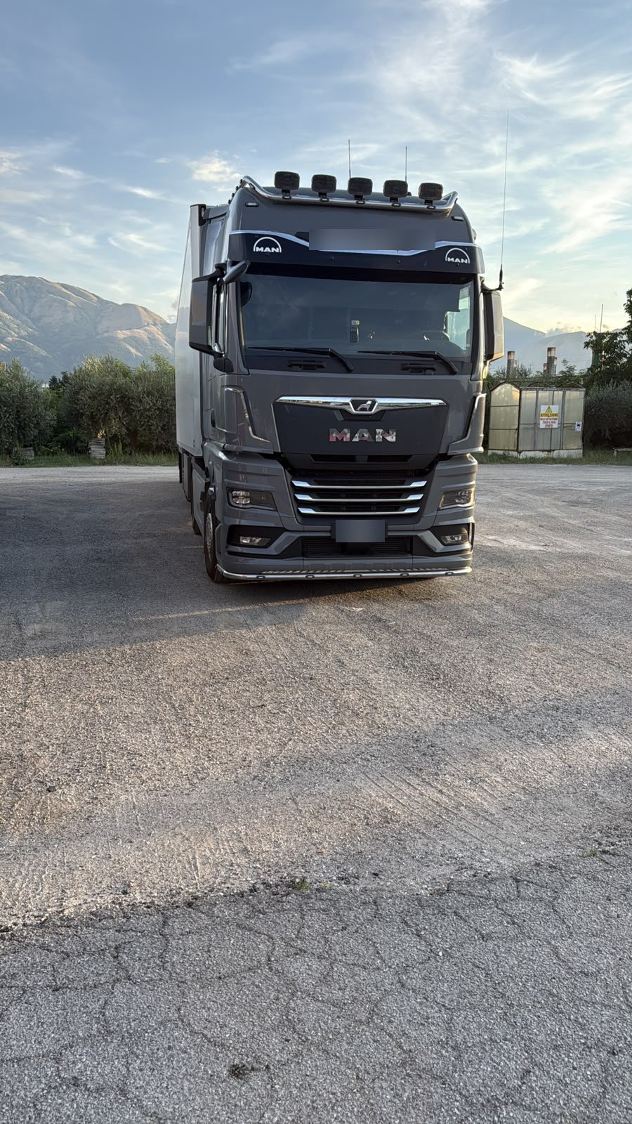 Il camion C&C grigio antracite in piazzale, di giorno, con le montagne sullo sfondo