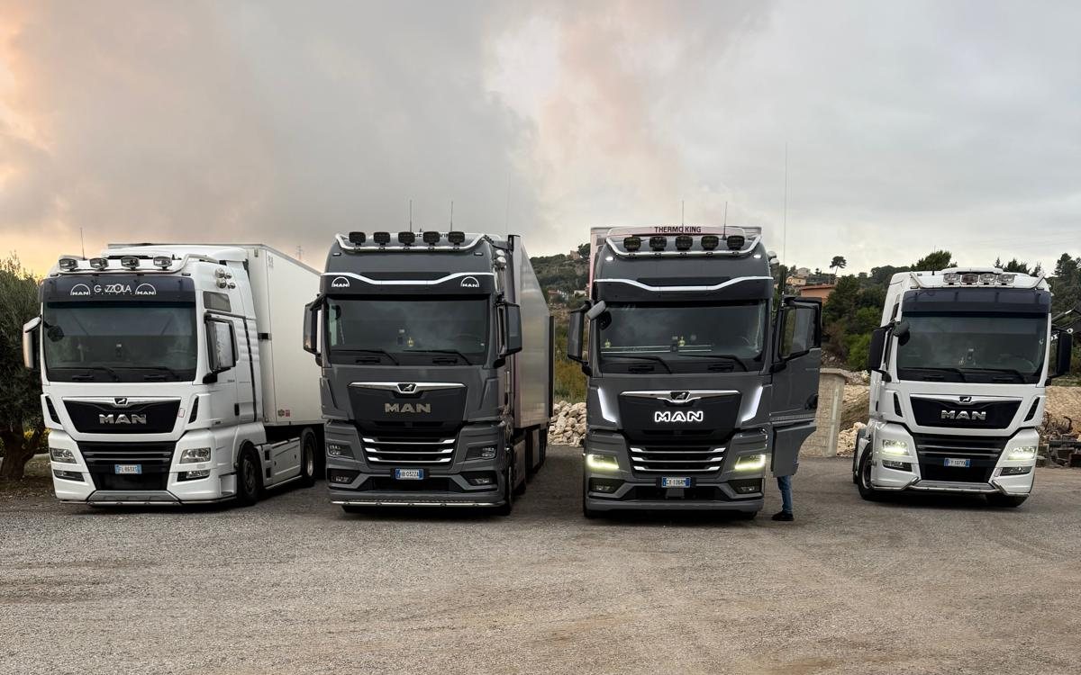 Quattro camion MAN della flotta schierati nel piazzale al tramonto